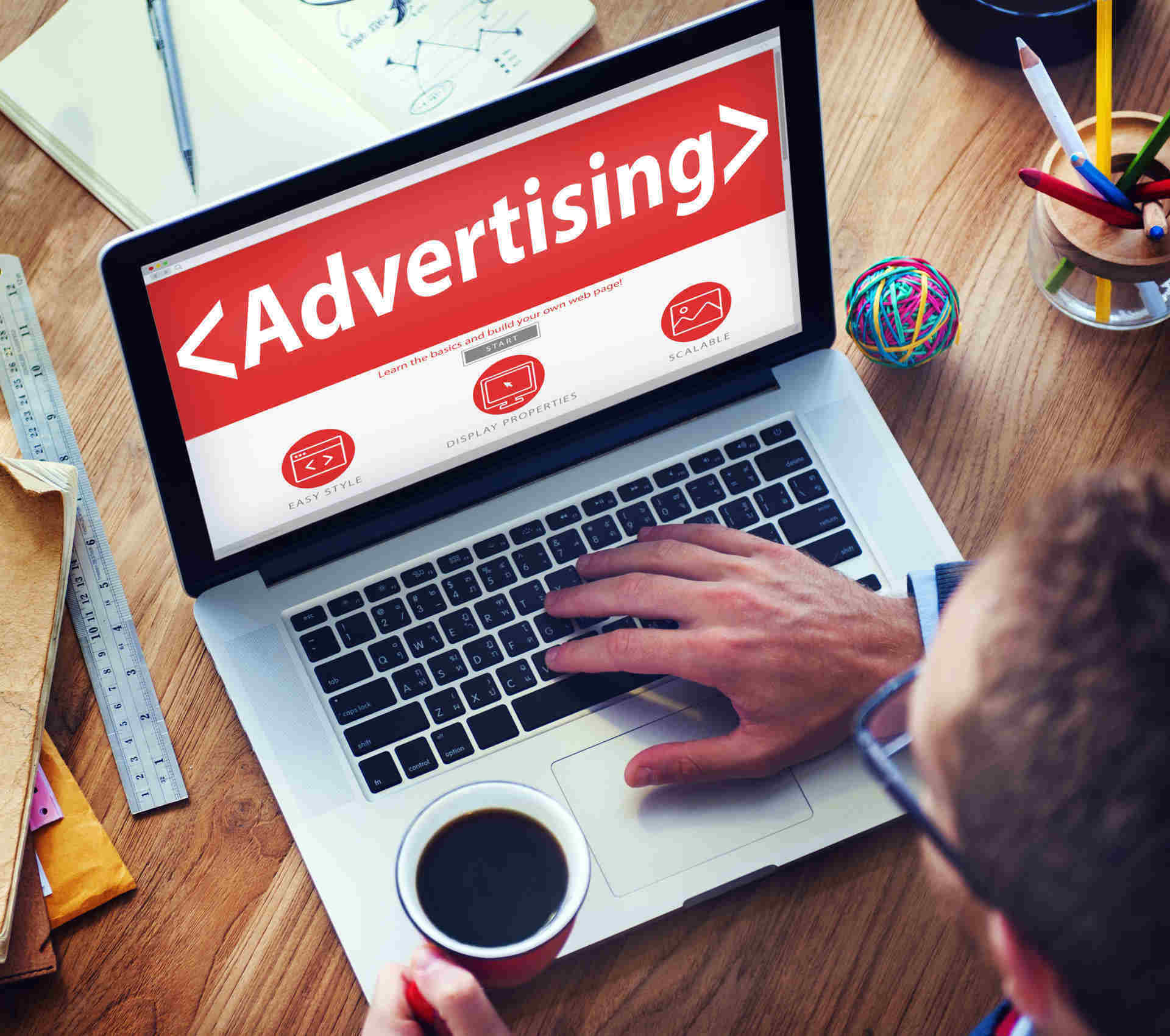 Marketer working on a laptop showing an online advertising dashboard